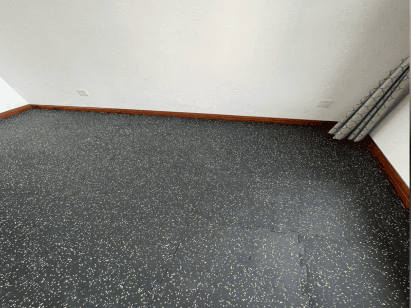 Suelo de caucho con motas de color a juego con el logotipo del gimnasio